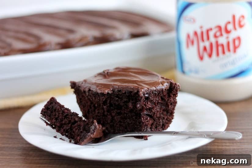 A large rectangular Heavenly Chocolate Cake, fully frosted with chocolate cream cheese icing, on a cooling rack. From DessertNowDinnerLater.com