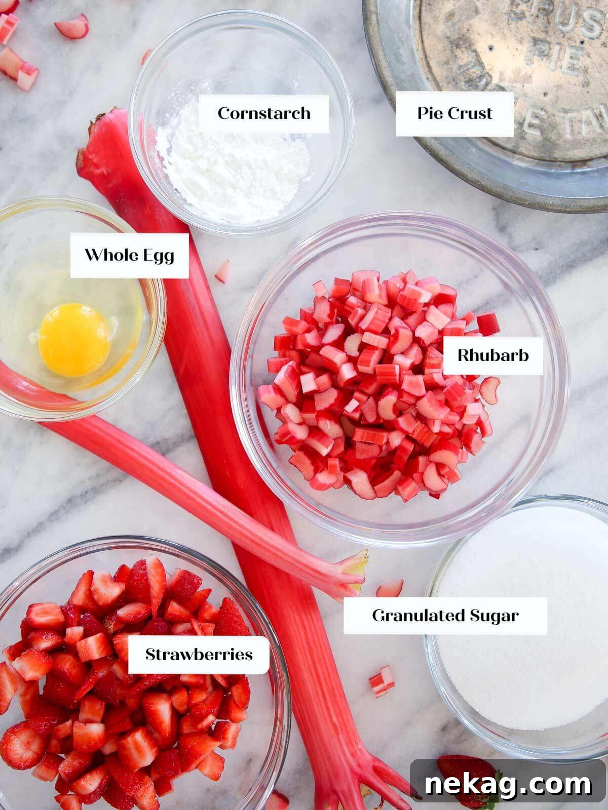 Strawberry Rhubarb Delight 3 Fresh ingredients for Strawberry Rhubarb Pie arranged beautifully on a marble surface, including vibrant strawberries, crisp rhubarb stalks, granulated sugar, and various flours.