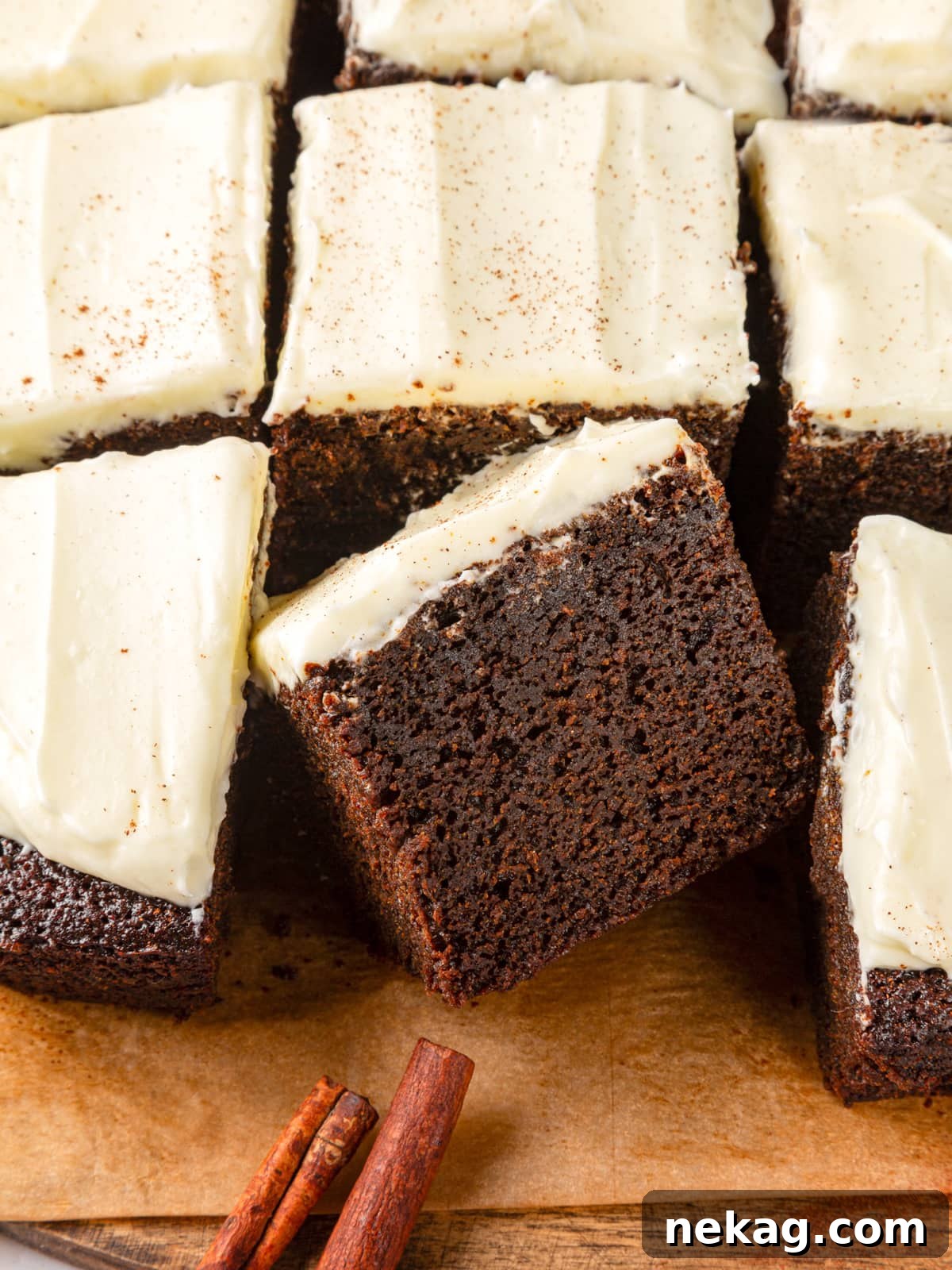 Several gingerbread cake pieces with cinnamon sticks reinforcing the cozy holiday flavor profile.