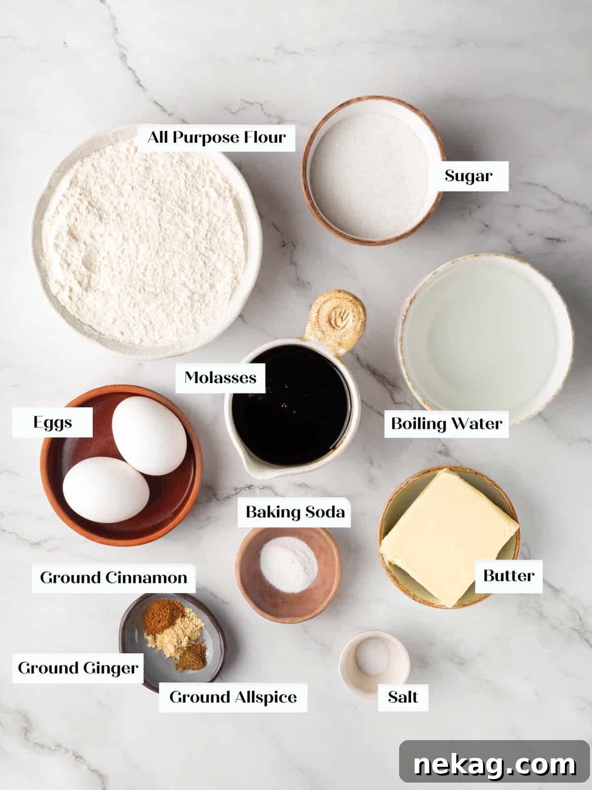 Butter, flour, spices, molasses, and eggs laid out for making homemade gingerbread cake.