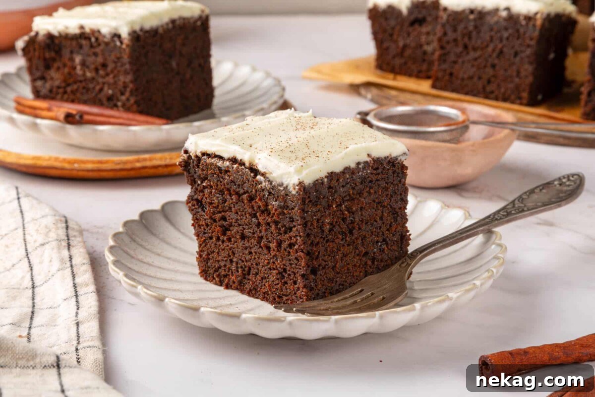 Single gingerbread cake square on a small plate highlighting fluffy interior and dark brown crumb.