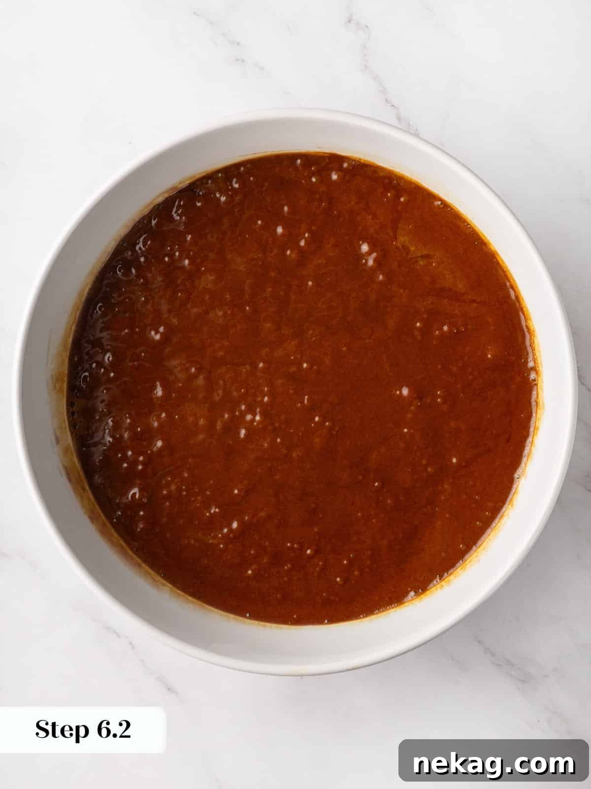 Smooth gingerbread cake batter in a mixing bowl, ready to pour into the pan.