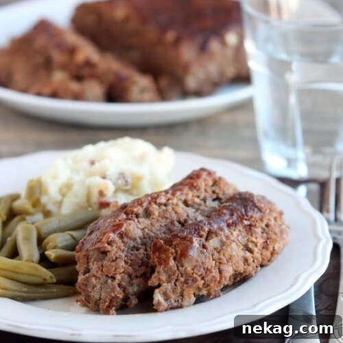 Steak Lovers' Meatloaf - A1 steak sauce, garlic, and onions on the inside, with more steak sauce slathered on the outside, makes this meatloaf both moist and delicious! From DessertNowDinnerLater.com