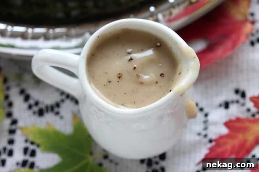 Rich, homemade turkey gravy drizzled over mashed potatoes, showcasing its smooth texture.