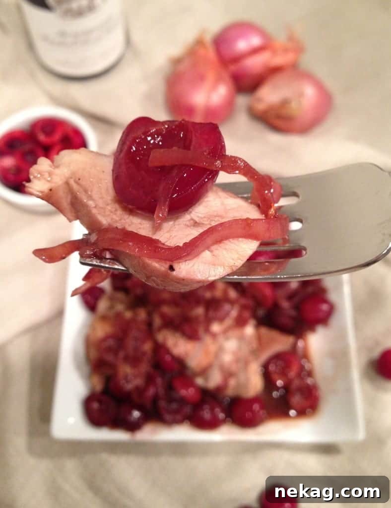 Cherry Wine Glazed Chicken 3 Chicken pieces simmering in a rich, dark cherry wine sauce within a large, rustic skillet.