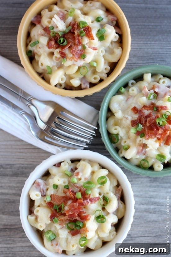 Another enticing view of White Cheddar Bacon Mac and Cheese served in a bowl, garnished with fresh green onions, highlighting its creamy texture and rich appearance.