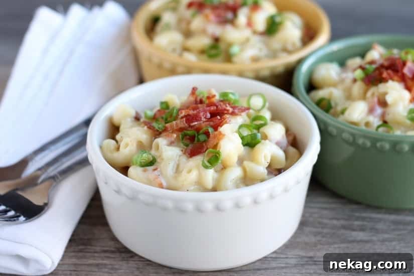 Close-up overhead view of the White Cheddar Bacon Mac and Cheese, garnished with extra crispy bacon bits and green onions, ready to be served.