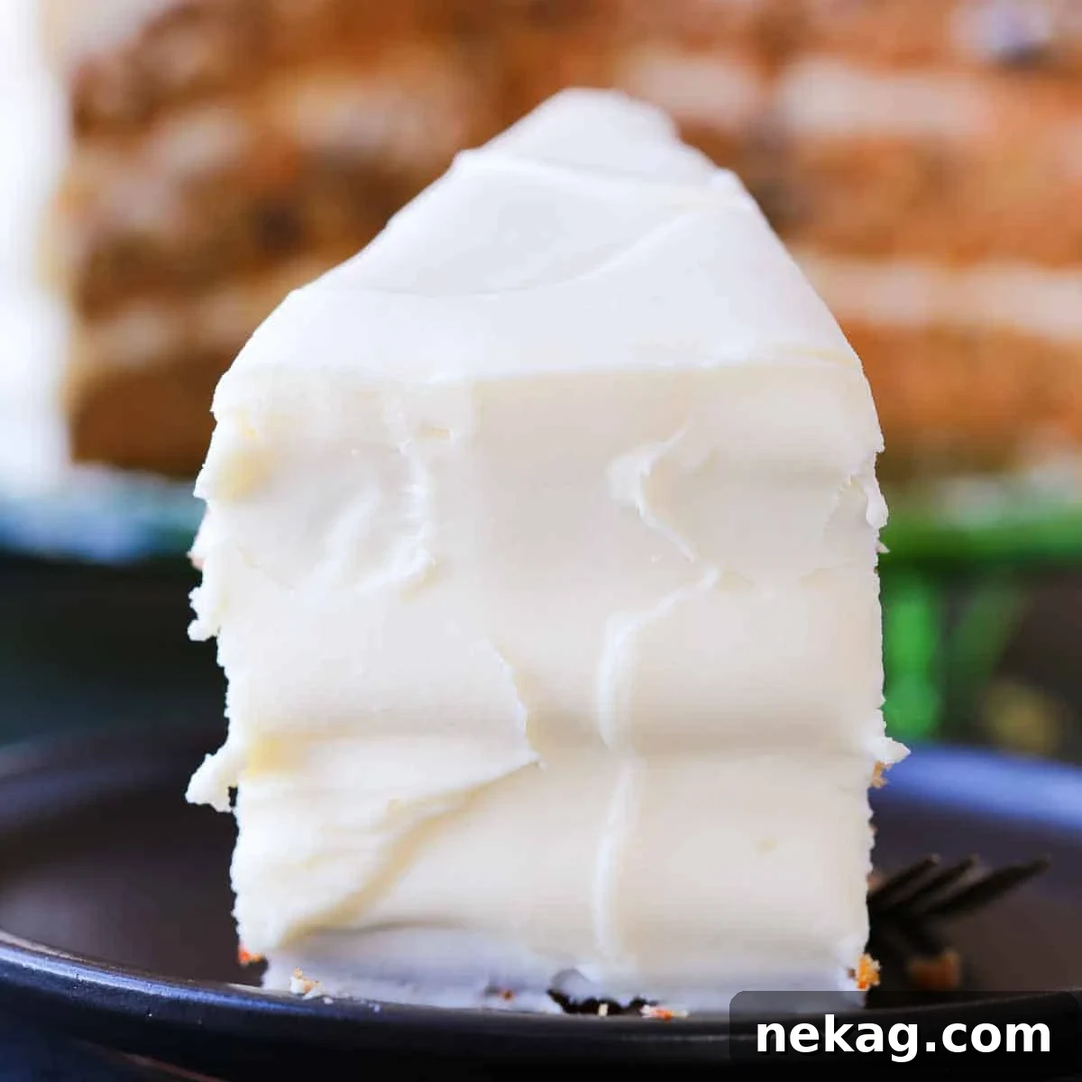 Slice of easy carrot cake with thick cream cheese frosting.