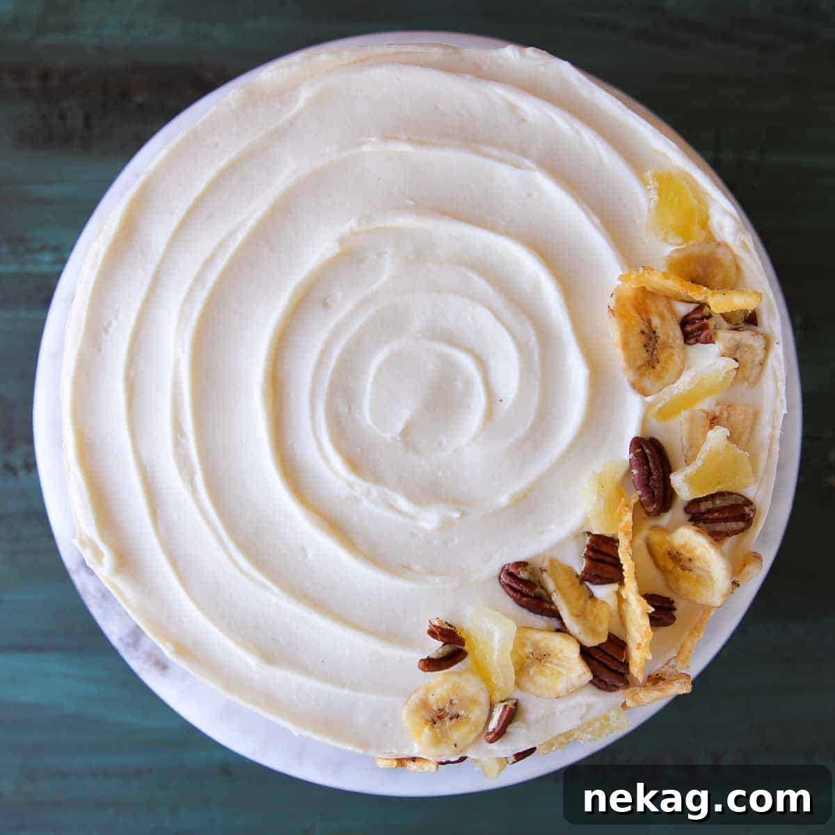 Unsliced swirled cake with cream cheese buttercream frosting on top.