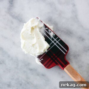 Peppermint American Buttercream on a tartan spatula, ready to be spread on a festive treat.