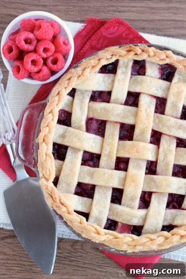 Raspberry Pie with a perfect Lattice Crust and an elegant Braided Edge, showcasing intricate detail and golden brown finish.