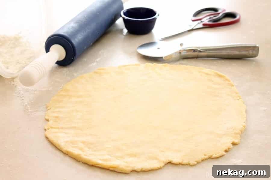 The second half of the pie crust dough rolled out and cut into even 1-inch strips using a pizza cutter, prepared for weaving.