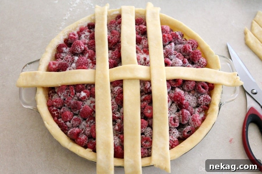 Two additional vertical pie crust strips placed parallel to the central vertical strip, lying on top of the horizontal strip.