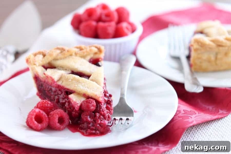 Sliced Raspberry Pie, revealing its juicy, red filling and flaky, golden crust, perfect for holiday gatherings.