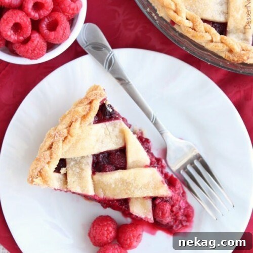 A vibrant Raspberry Pie, perfectly baked with a lattice crust, ideal for any dessert table.