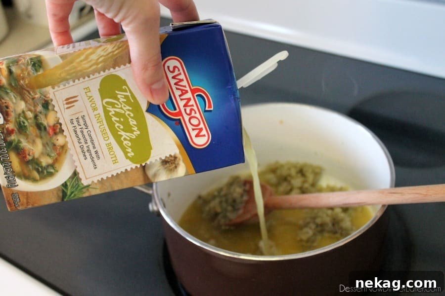 Pouring Swanson Tuscan Chicken Flavor Infused Broth into a saucepan with sautéed onions, garlic, and roux.
