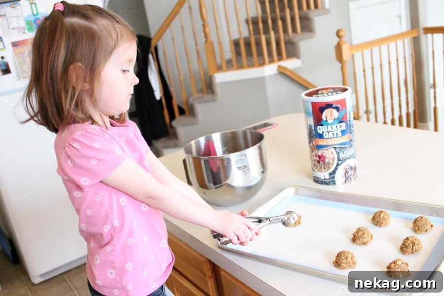 Scooping Gingersnap Oatmeal Cookie dough onto a baking sheet.