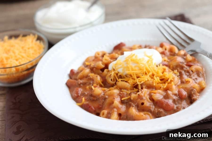 A wide shot of a pot filled with Chili Mac and Cheese, showing the macaroni mixed with chili and cheese sauce, ready to be served.