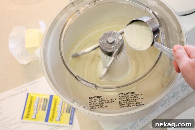 Dough in a mixing bowl, forming a ball after adding flour