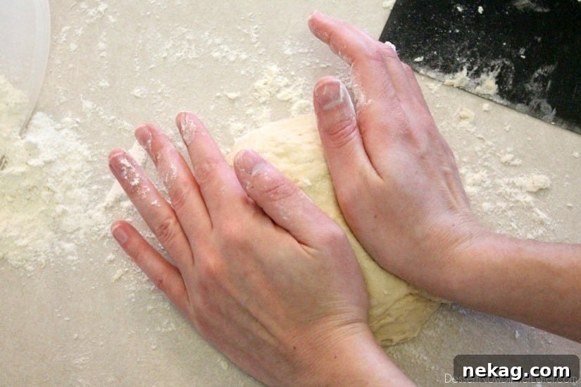 Dough resting on a lightly floured surface, covered with a towel