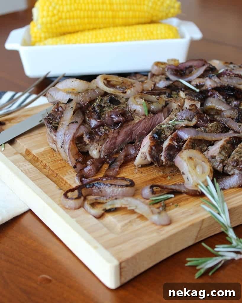 Succulent Rosemary Rubbed Rib-Eye steak with beautifully Charred Red Onions, garnished with fresh herbs, ready to serve.