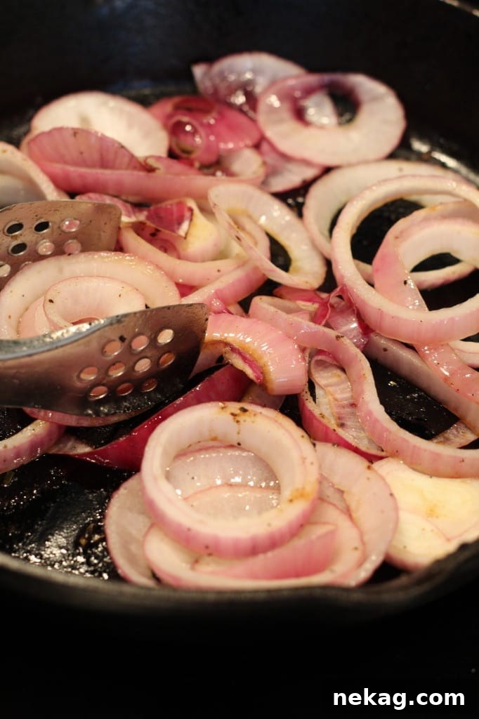 Vibrant red onions, uniformly sliced into thick rings, prepared and ready for charring.
