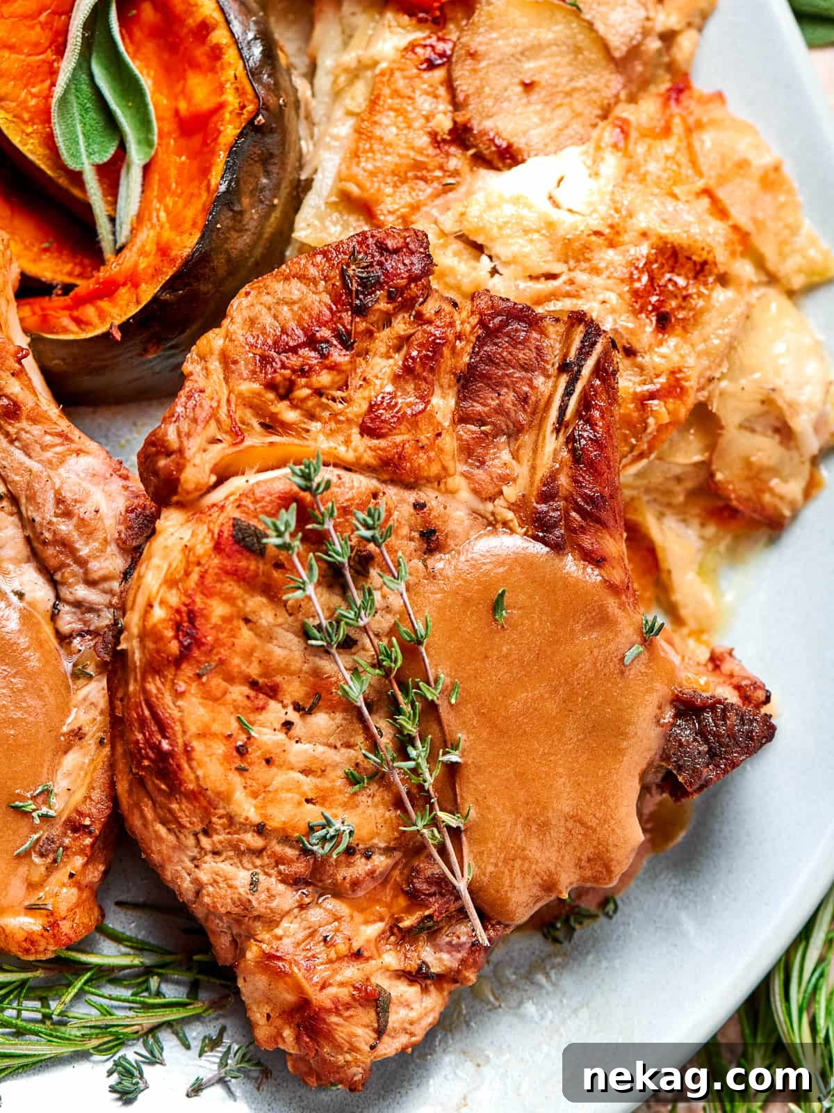 Pork chop topped with smooth applesauce sauce and fresh thyme leaves.