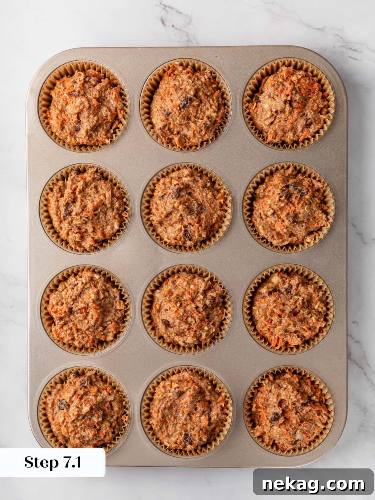 Muffin batter is evenly portioned into the lined tin cups, ready for baking in the oven.