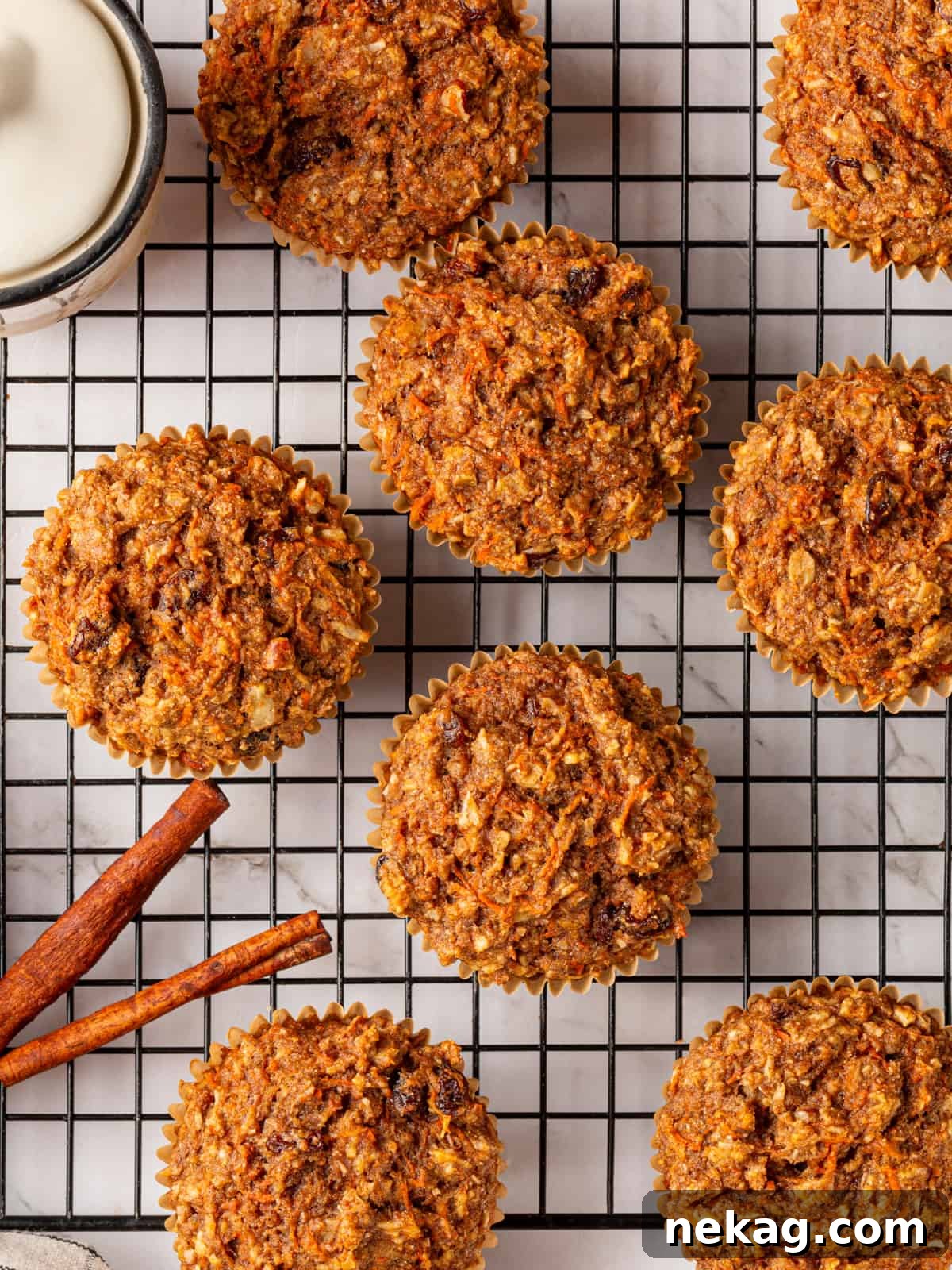 Delicious whole wheat morning glory muffins beautifully arranged on a cooling rack, styled with elegant cinnamon sticks.