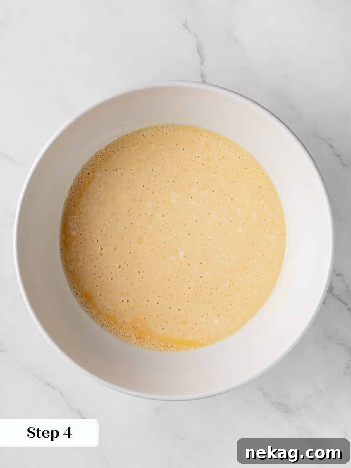 A bowl showcasing the well-blended wet ingredients, forming the rich base of the morning glory muffin batter.