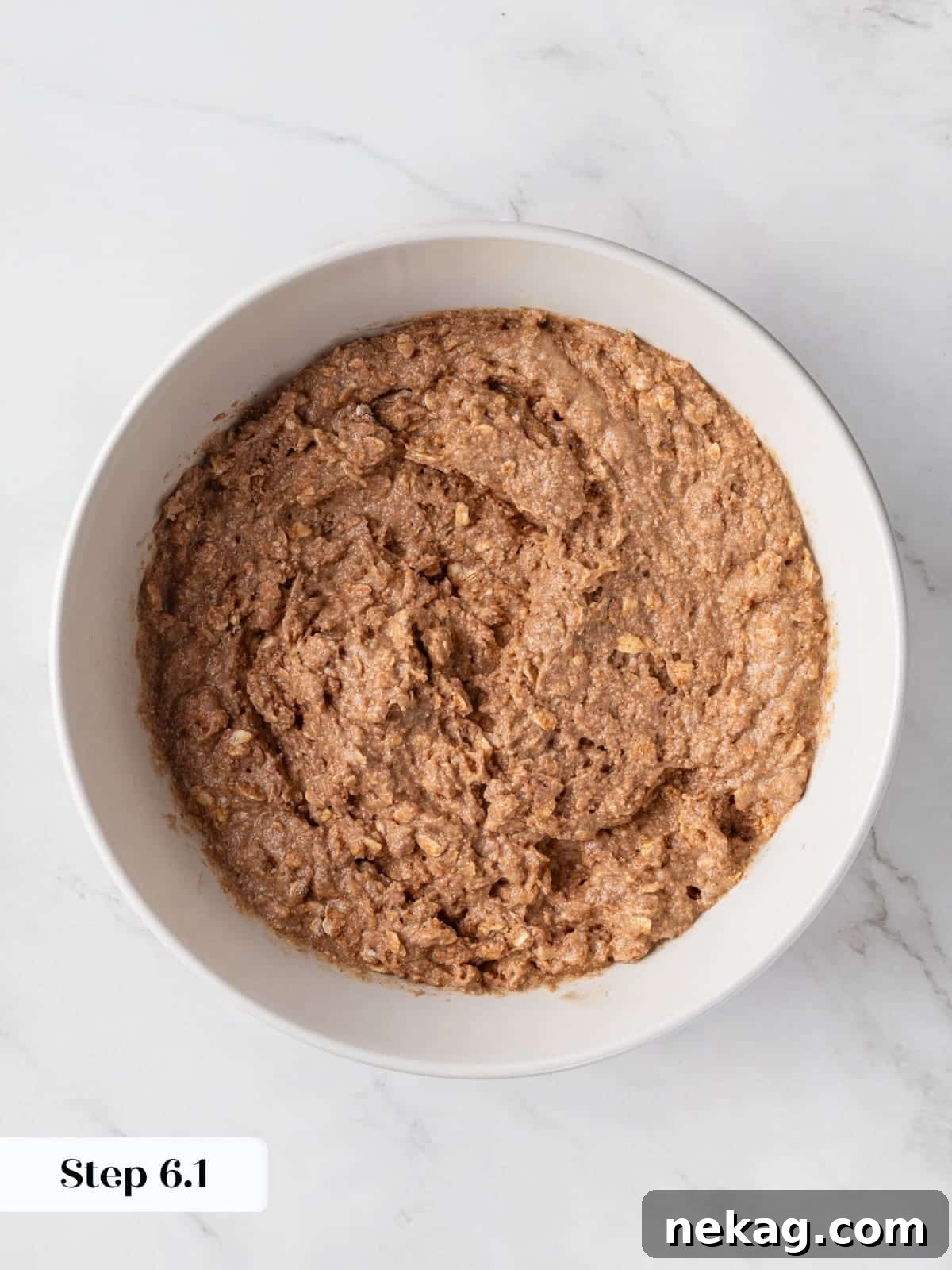 The initial stage of muffin batter coming together, as dry ingredients are slowly incorporated into the wet mixture.