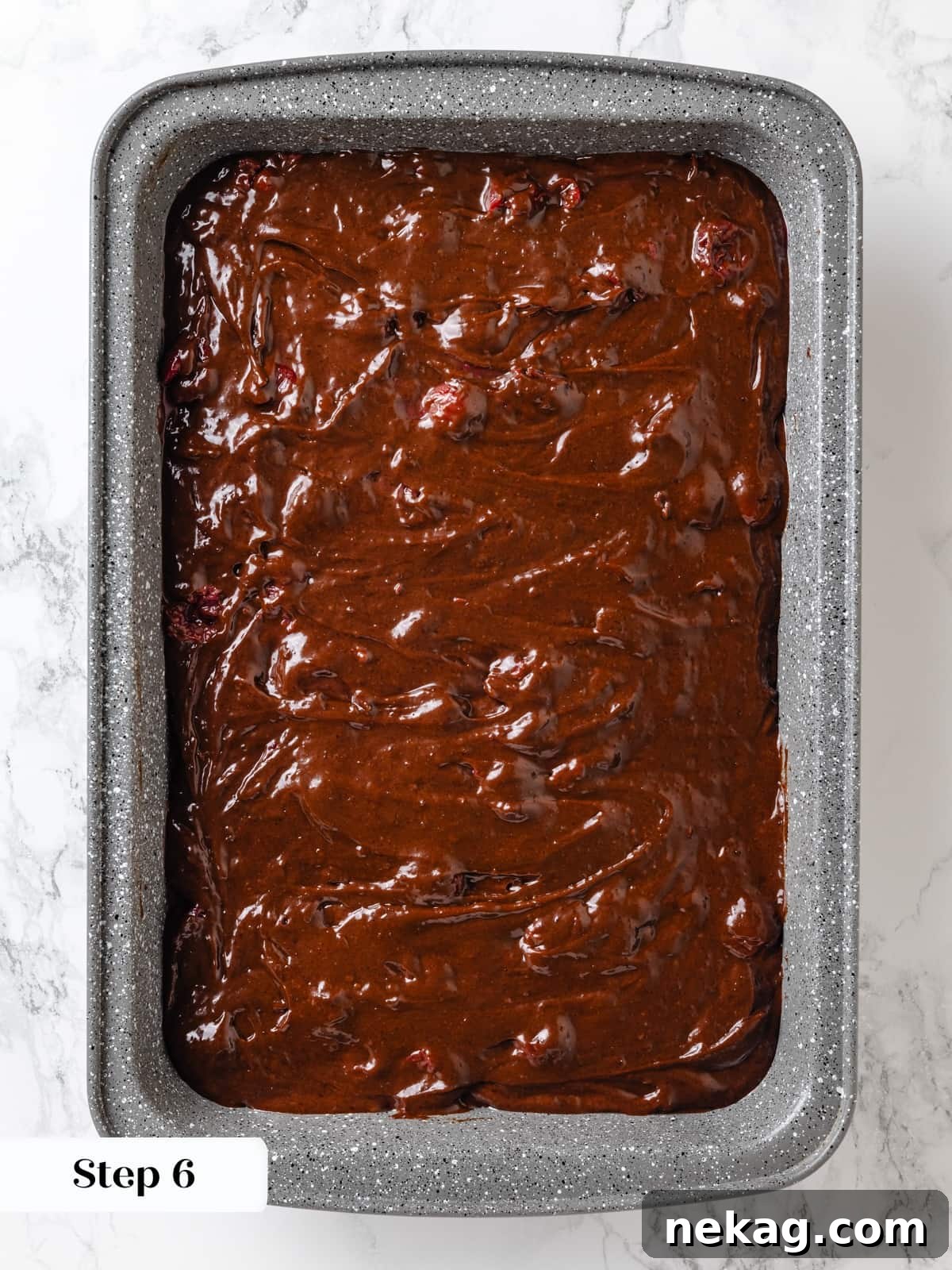 Chocolate cherry cake batter poured into prepared baking pan, ready for the oven.