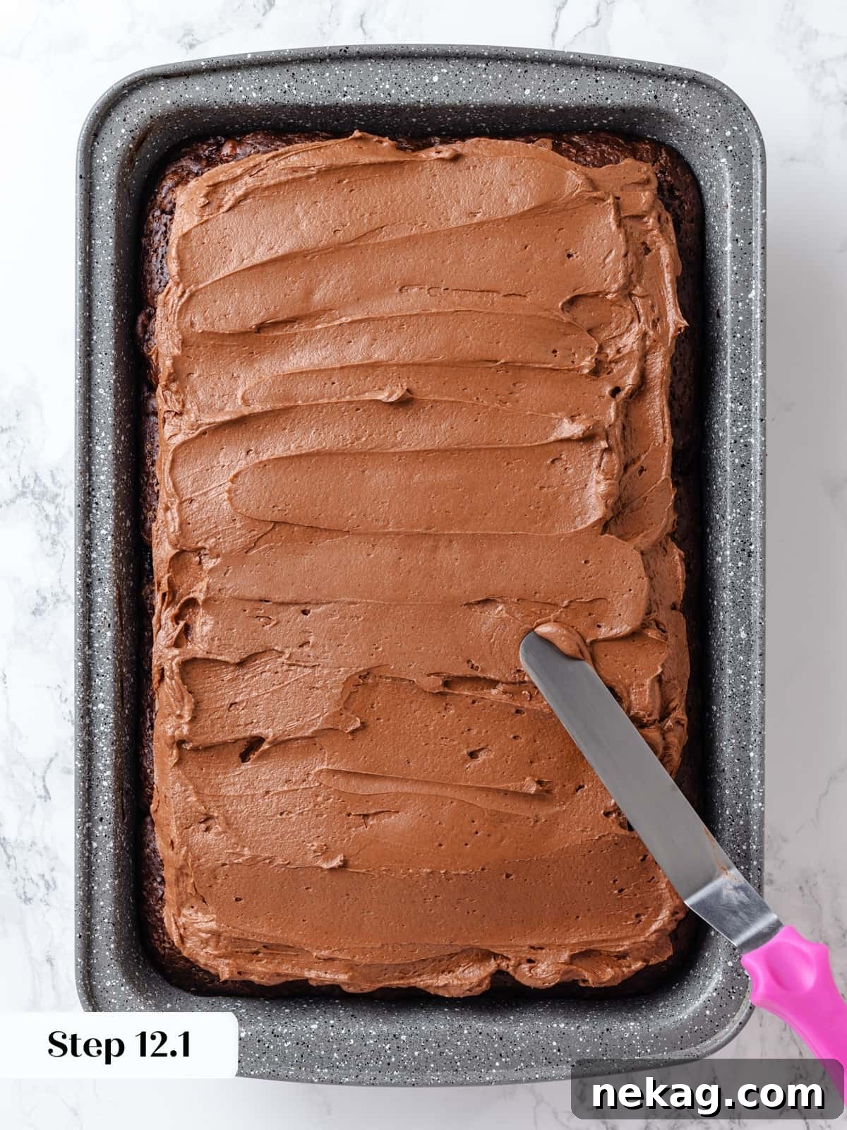 Chocolate cream cheese frosting evenly layered over the cooled chocolate cake before decorative swirling.