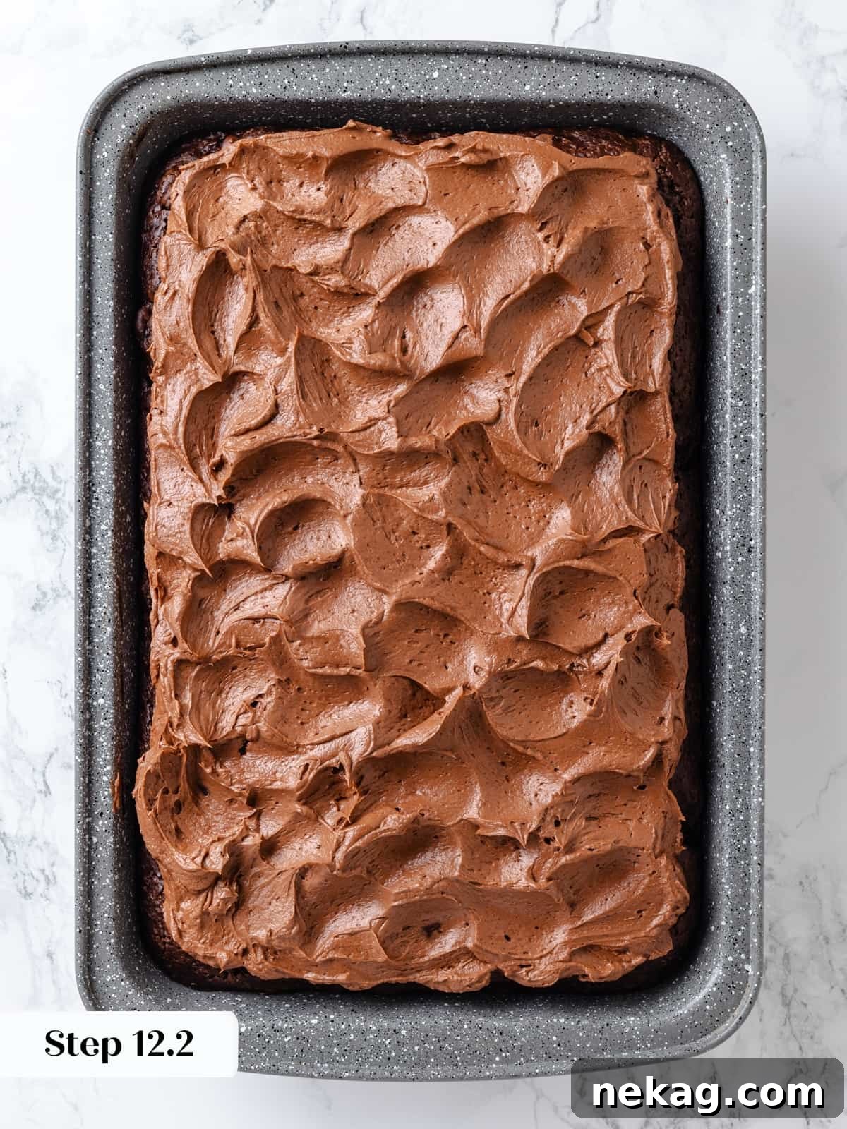 Rich chocolate cream cheese frosting artfully swirled decoratively across the top of the baked cake.