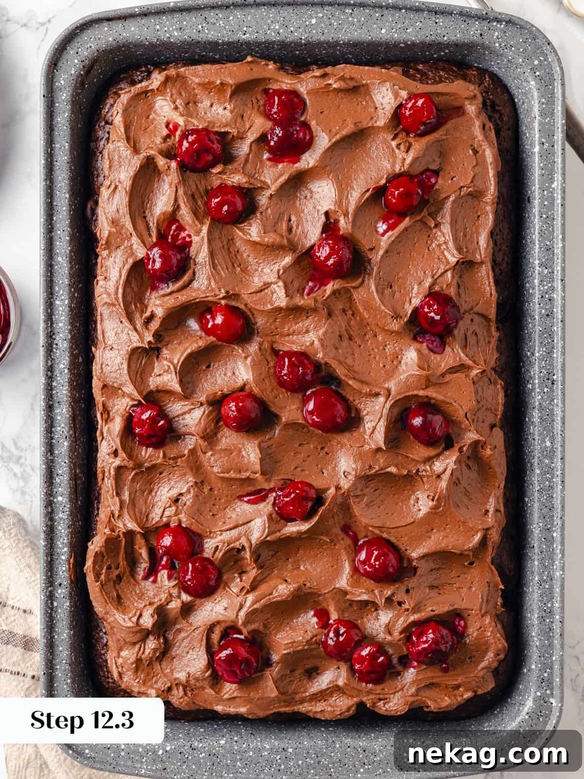 Fresh cherries gently spread over the swirled chocolate cream cheese frosting on the finished cake as garnish.