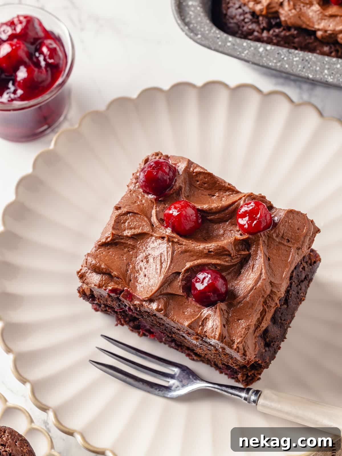 A perfectly plated chocolate cherry cake slice, showing its moist texture and rich frosting, ready to be enjoyed.