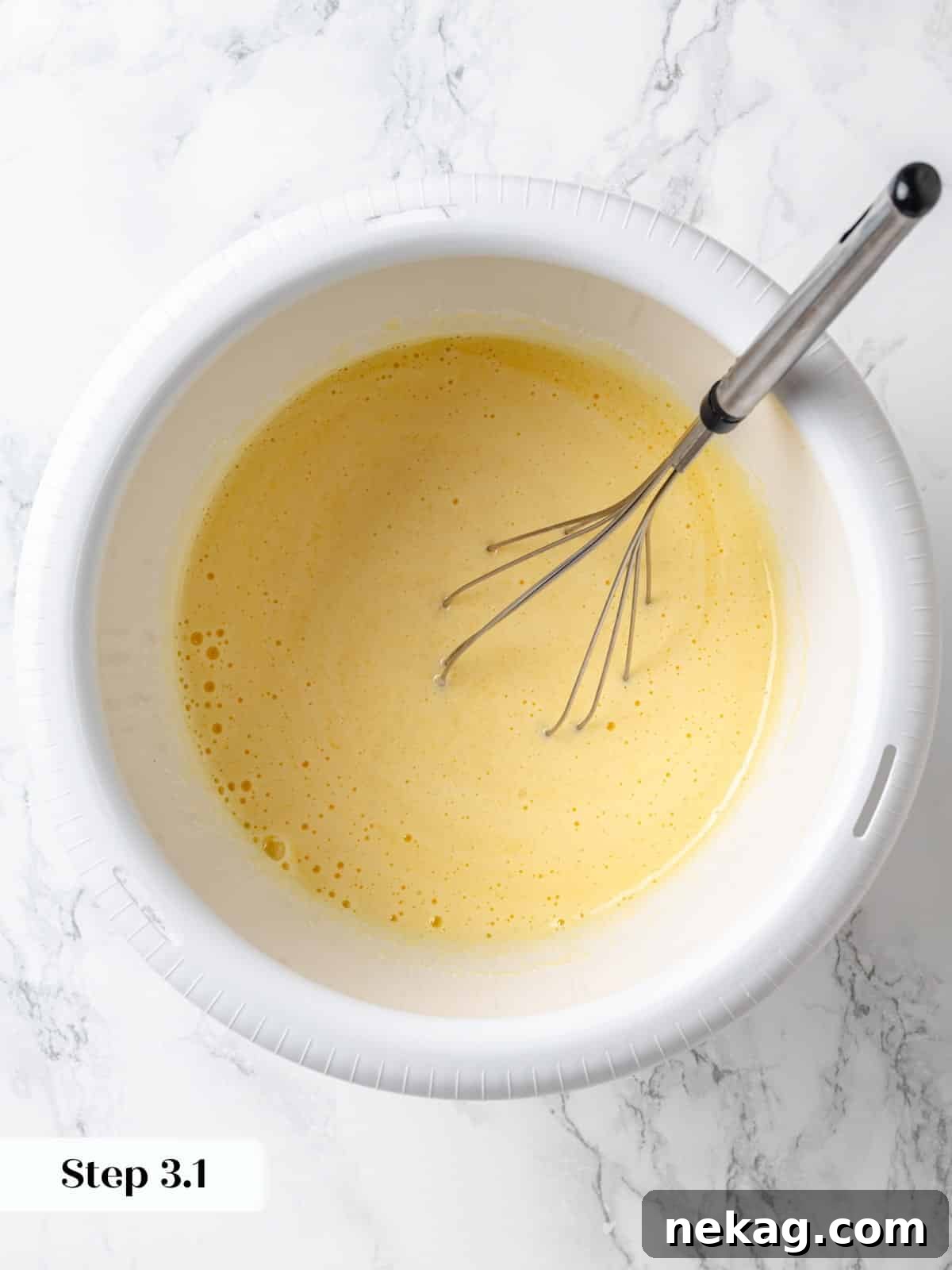 Eggs, vanilla extract, and granulated sugar whisked together until light and frothy for chocolate cake batter.
