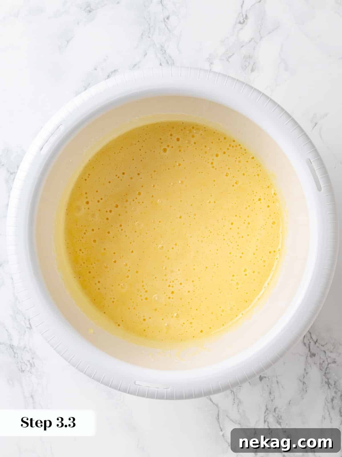Wet ingredients (eggs, vanilla, sugar, oil) blended together smoothly and emulsified in a bowl for chocolate cherry cake.