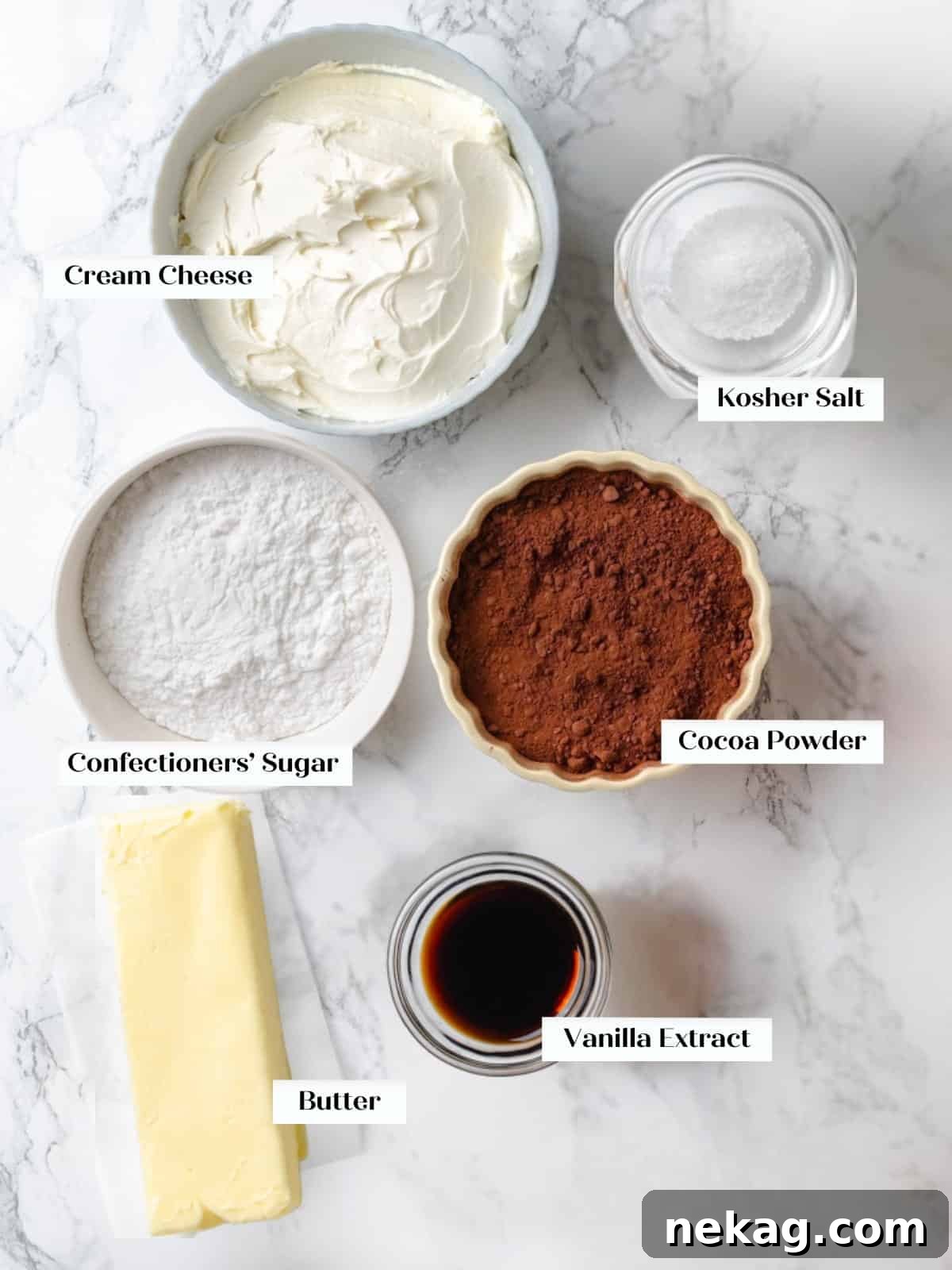 Carefully arranged baking ingredients including cream cheese, butter, cocoa powder, and powdered sugar, ready for making chocolate cream cheese frosting.