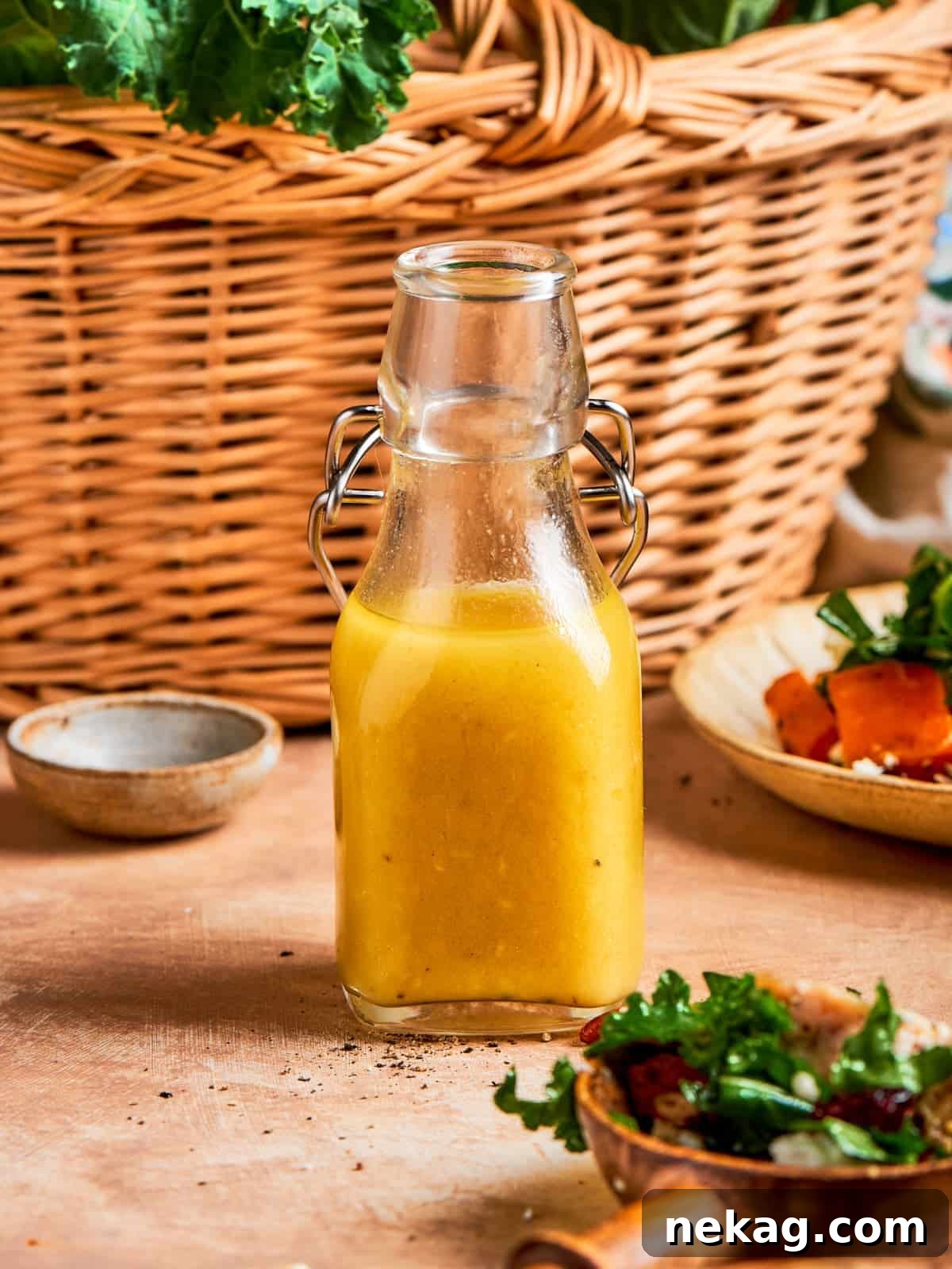 Bottle of homemade champagne vinaigrette standing in front of a woven kitchen basket, showcasing its elegant simplicity.