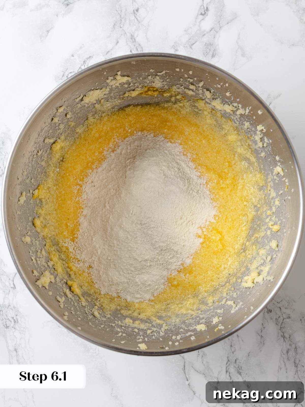 Zesty Lemon Delight Cake 11 Folding flour mixture into lemon cake batter gently and evenly.