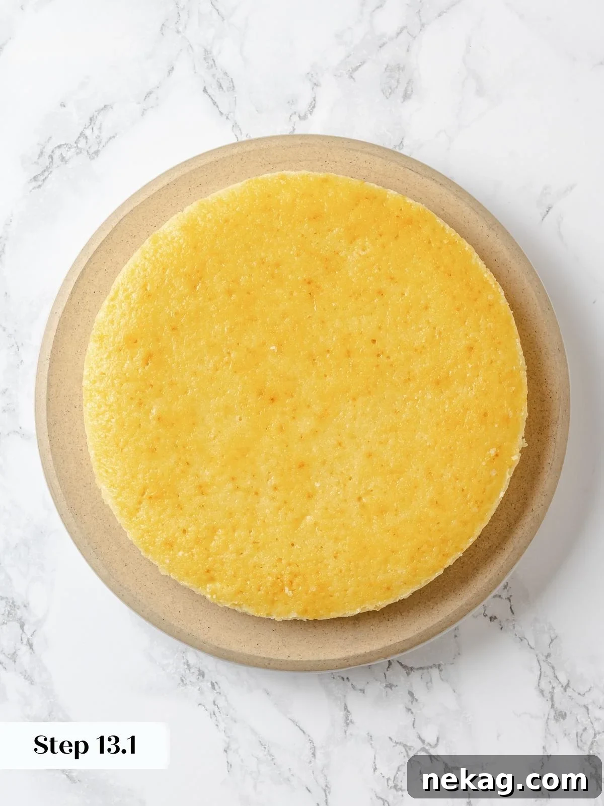 Zesty Lemon Delight Cake 23 Plain lemon cake layer placed on cake board before frosting is applied.