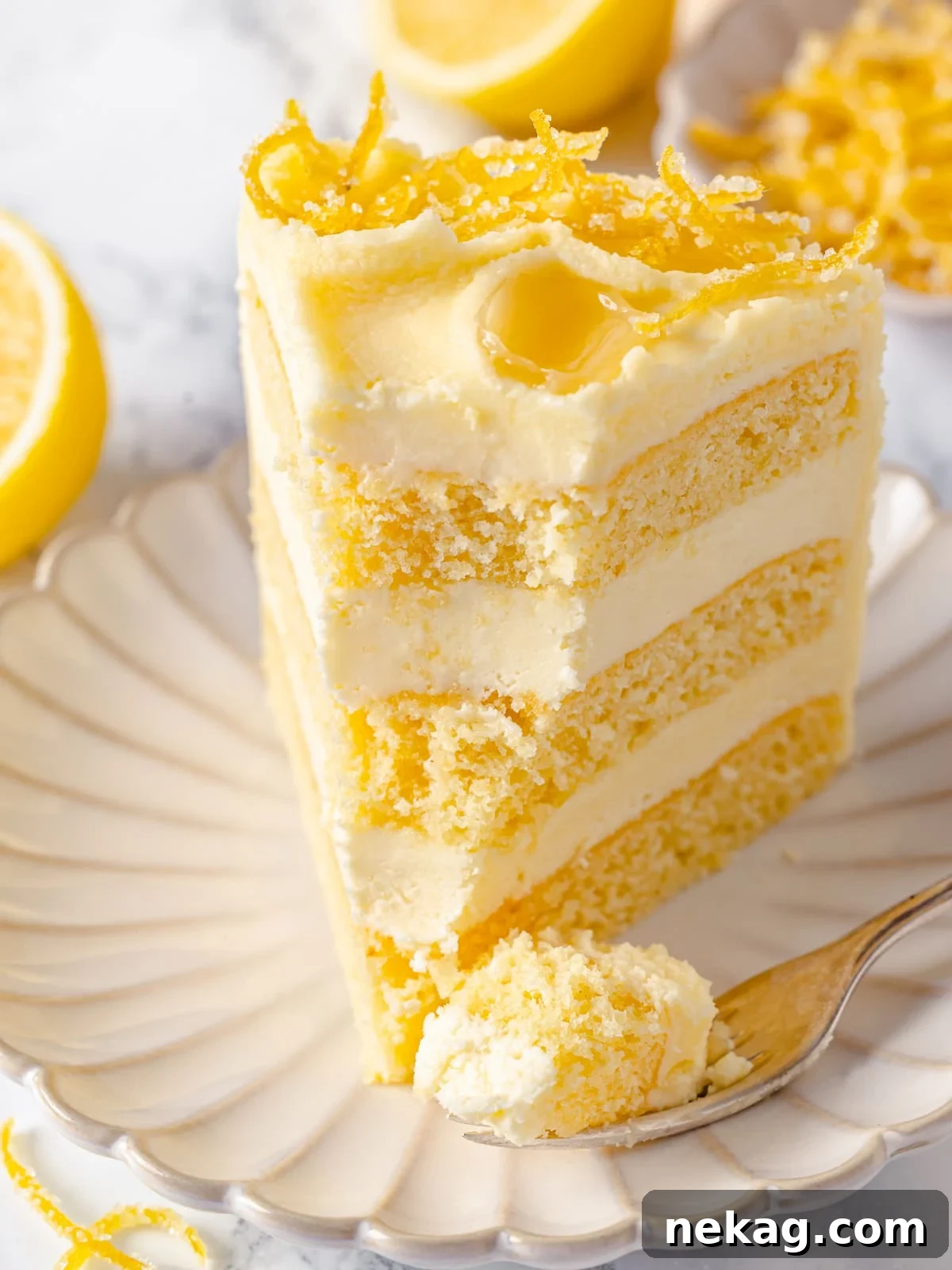 Zesty Lemon Delight Cake 25 Fork holding a bite of lemon cake with fluffy crumb and frosting.