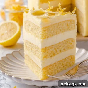Lemon cake slice served on scalloped plate with smooth buttercream and soft crumb.