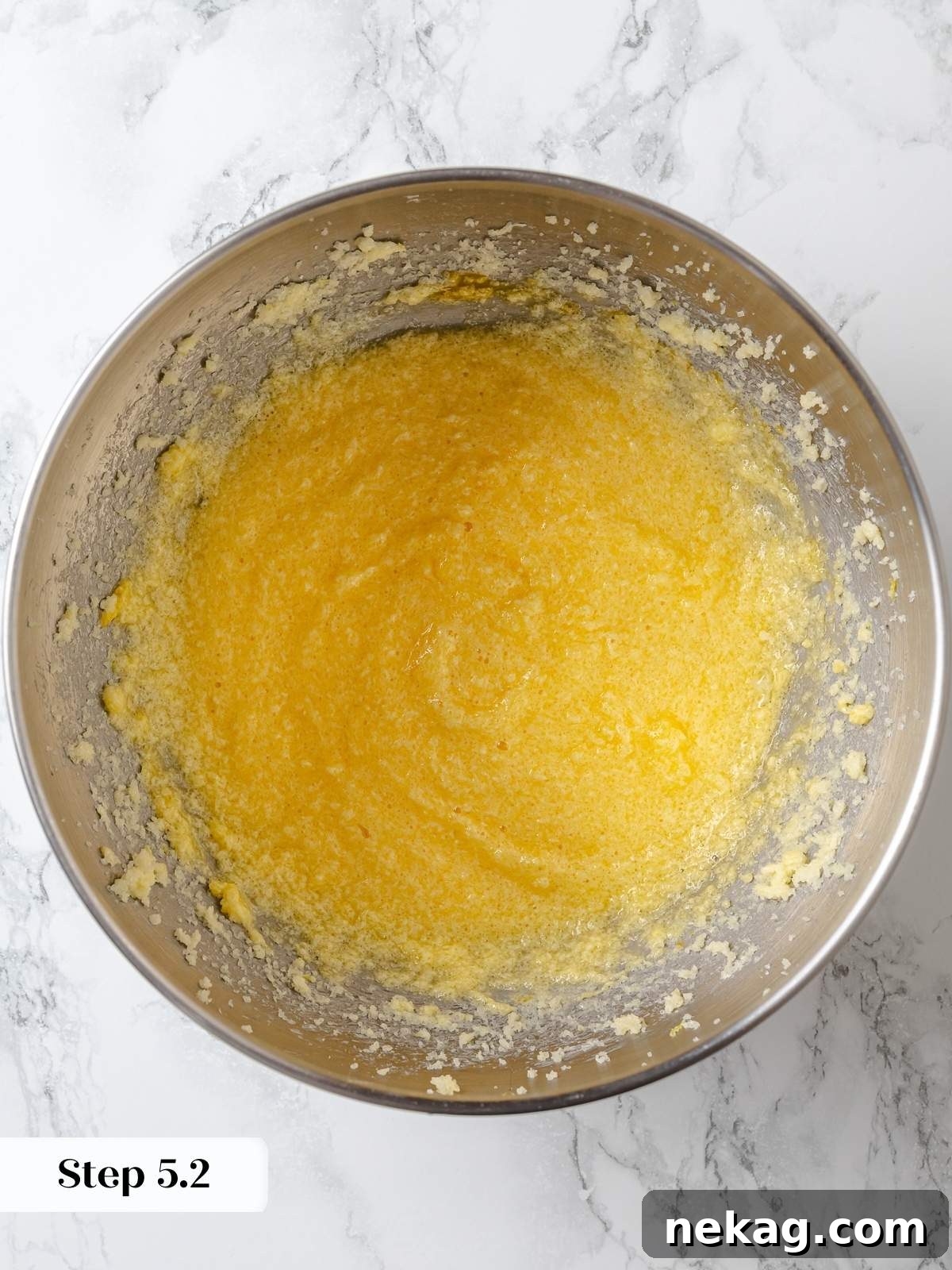 Zesty Lemon Delight Cake 10 Eggs being incorporated into creamed butter and sugar for lemon cake batter.