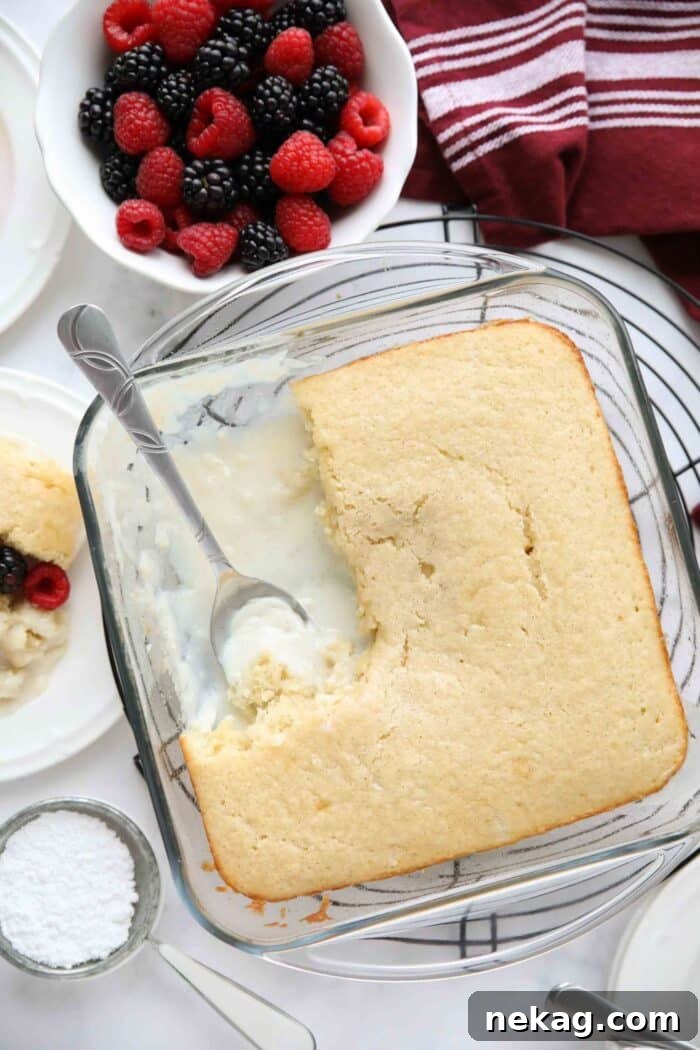 Top-down view of a vanilla pudding cake in a baking pan, showing the golden cake layer on top and the subtle hint of creamy pudding below.