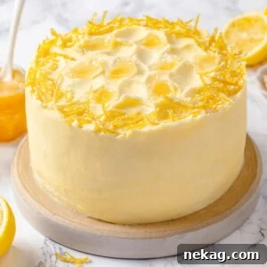 Cake topped with lemon Swiss meringue buttercream and fresh lemon peel garnish, offering a tempting glimpse of the recipe.