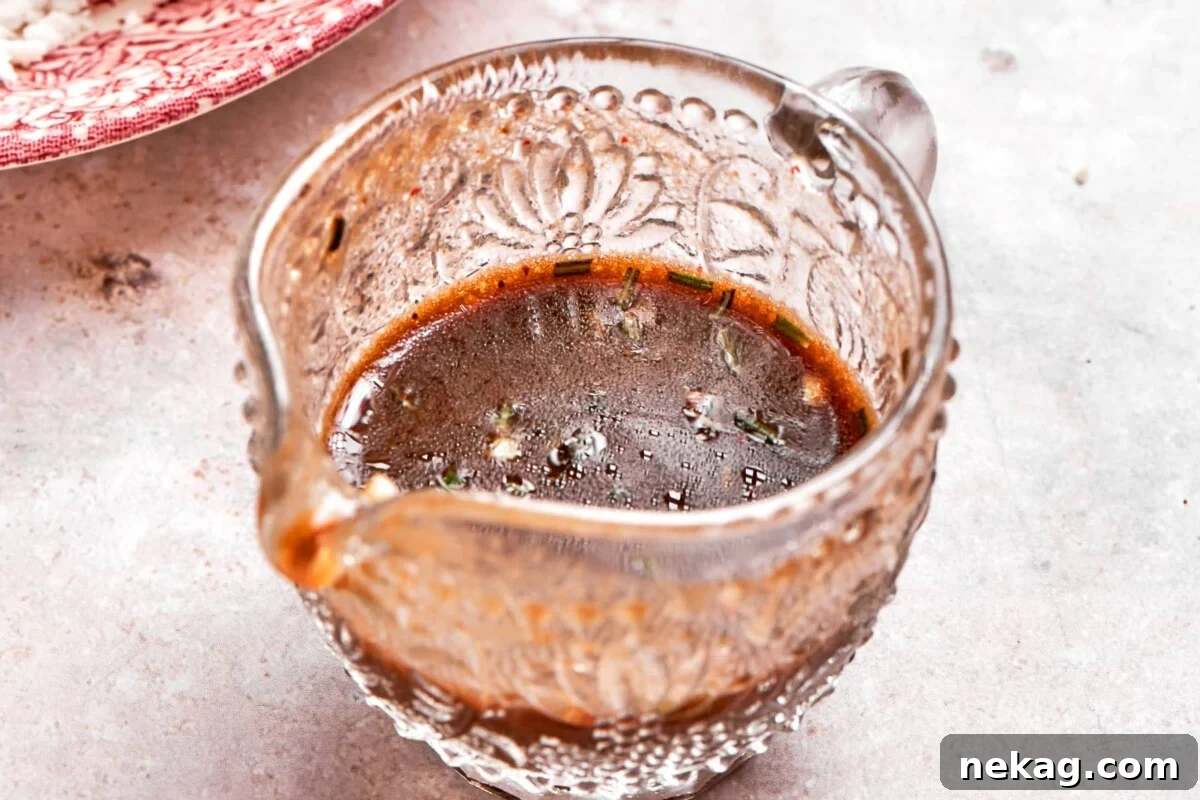 Lemon balsamic dressing presented in small glass gravy dish.