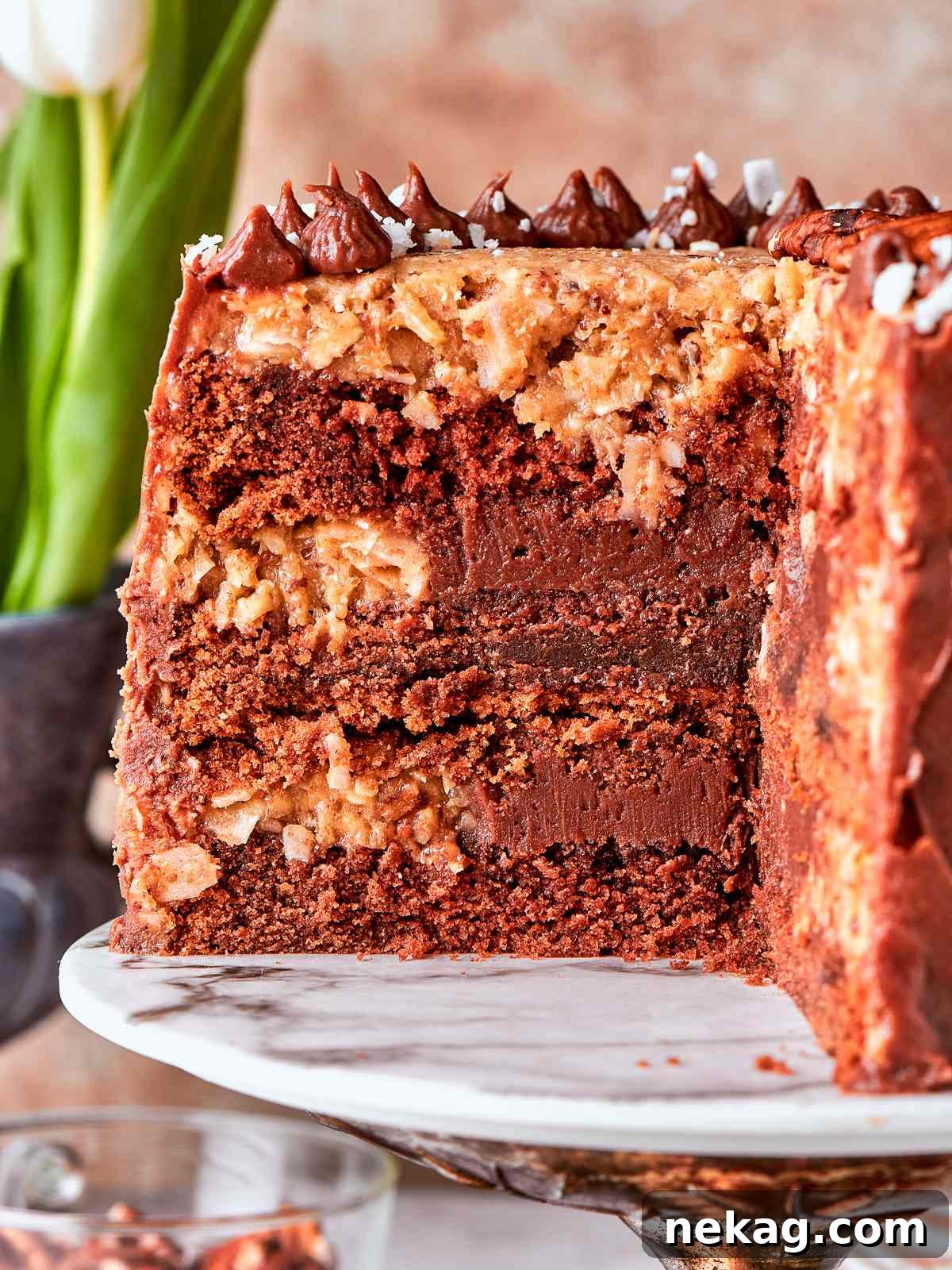 German chocolate cake displayed on marble cake stand with rustic topping.