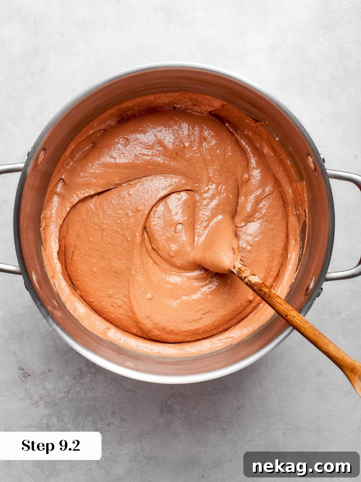 Thick chocolate batter with glossy texture prepared for baking cake layers.